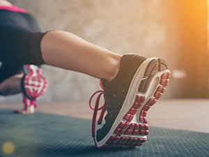 image femme faisant du gainage avec des chaussure de sport en intérieur